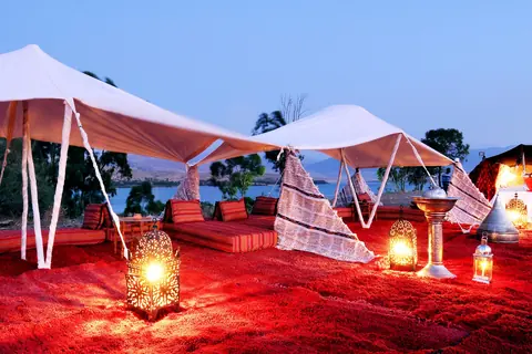 Tents and lanterns of a desert camp at dusk