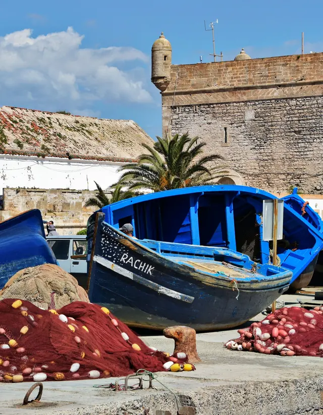 Blue fishing boats under the fort of Essaouira